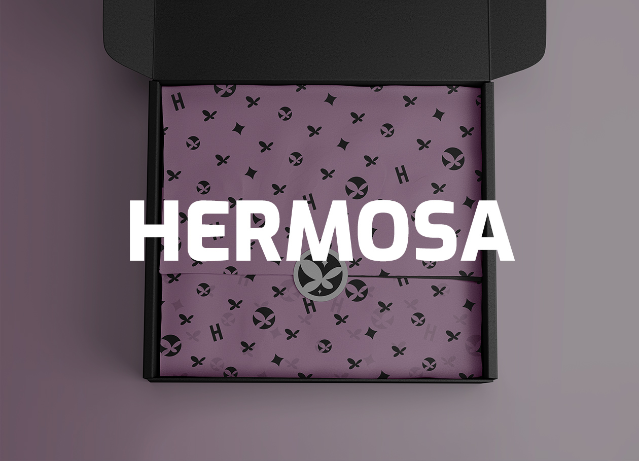 Open black box with purple wrapping paper featuring black symbols and a circular sticker with a butterfly logo.