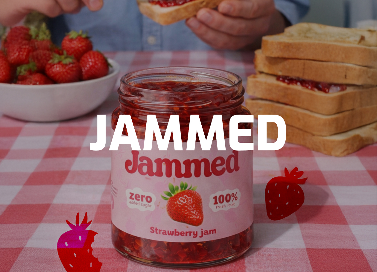 Brown and white puppy eating dry dog food from a metal bowl next to a bag of Burek dog food.