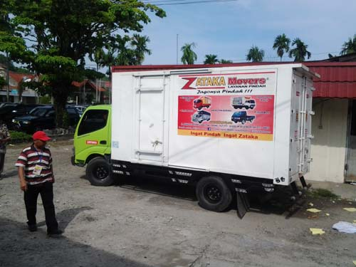 Foto proses pengepakan barang pecah belah dengan bahan protektif.