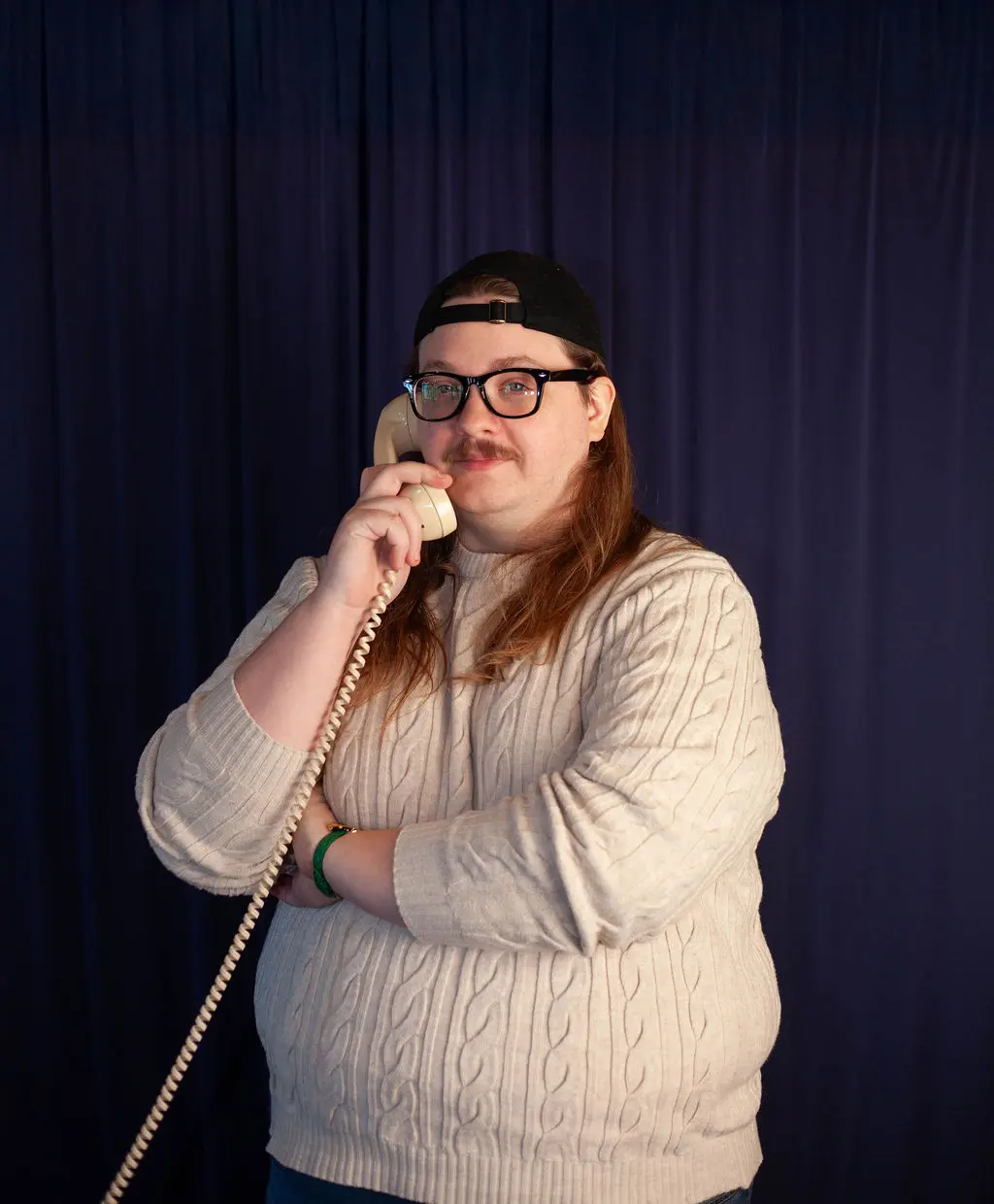A headshot of Charles answering a rotary phone