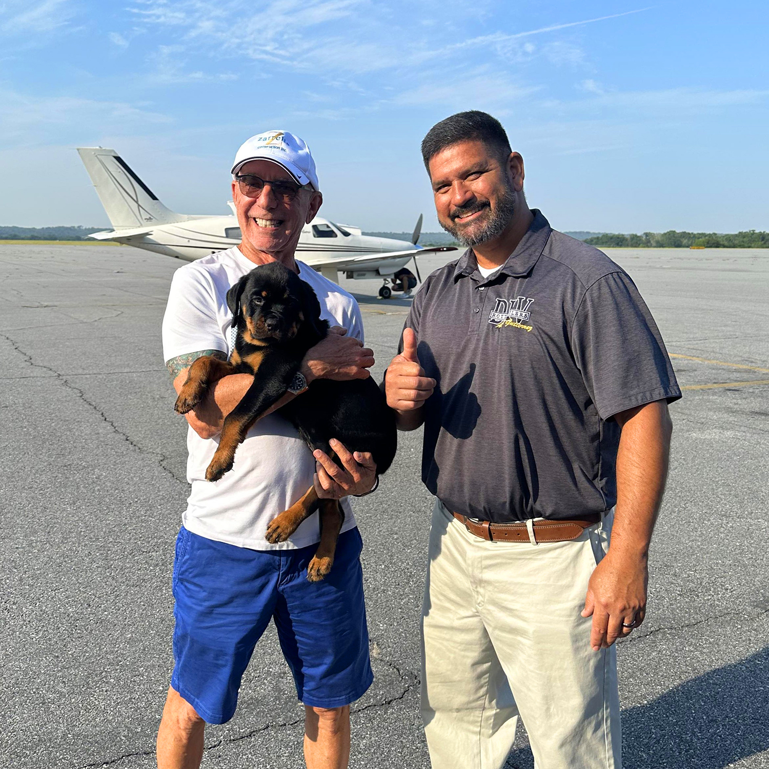 Professional in-person handoff of a German Rottweiler puppy by DKV Rottweilers at airport delivery.