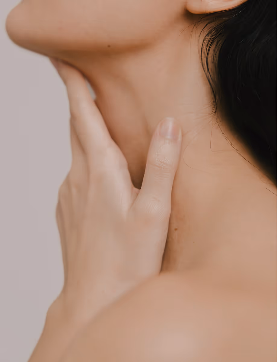 Close-up of a person's neck with their hand gently touching the side below the chin.