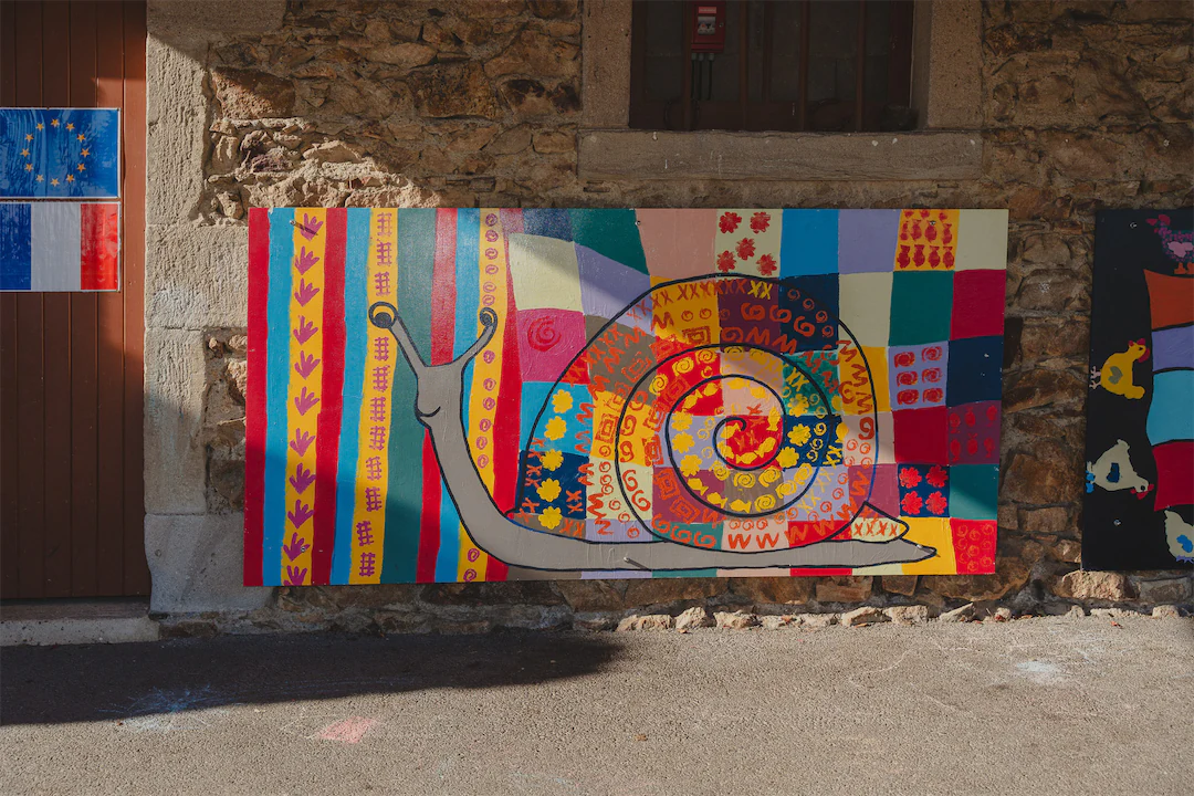 Peinture murale colorée d'un escargot avec une coquille en spirale décorée de motifs variés.