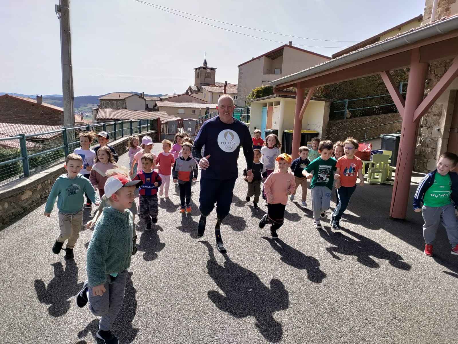 Les enfants courent aux côtés d'un coureur en situation d'handicap.