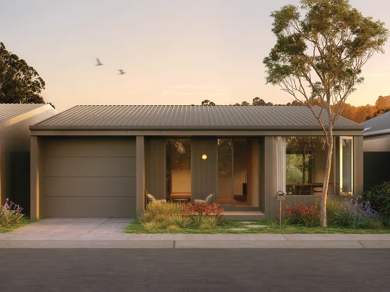 Single-story modern house with garage, large windows, small garden, and tree at sunset.