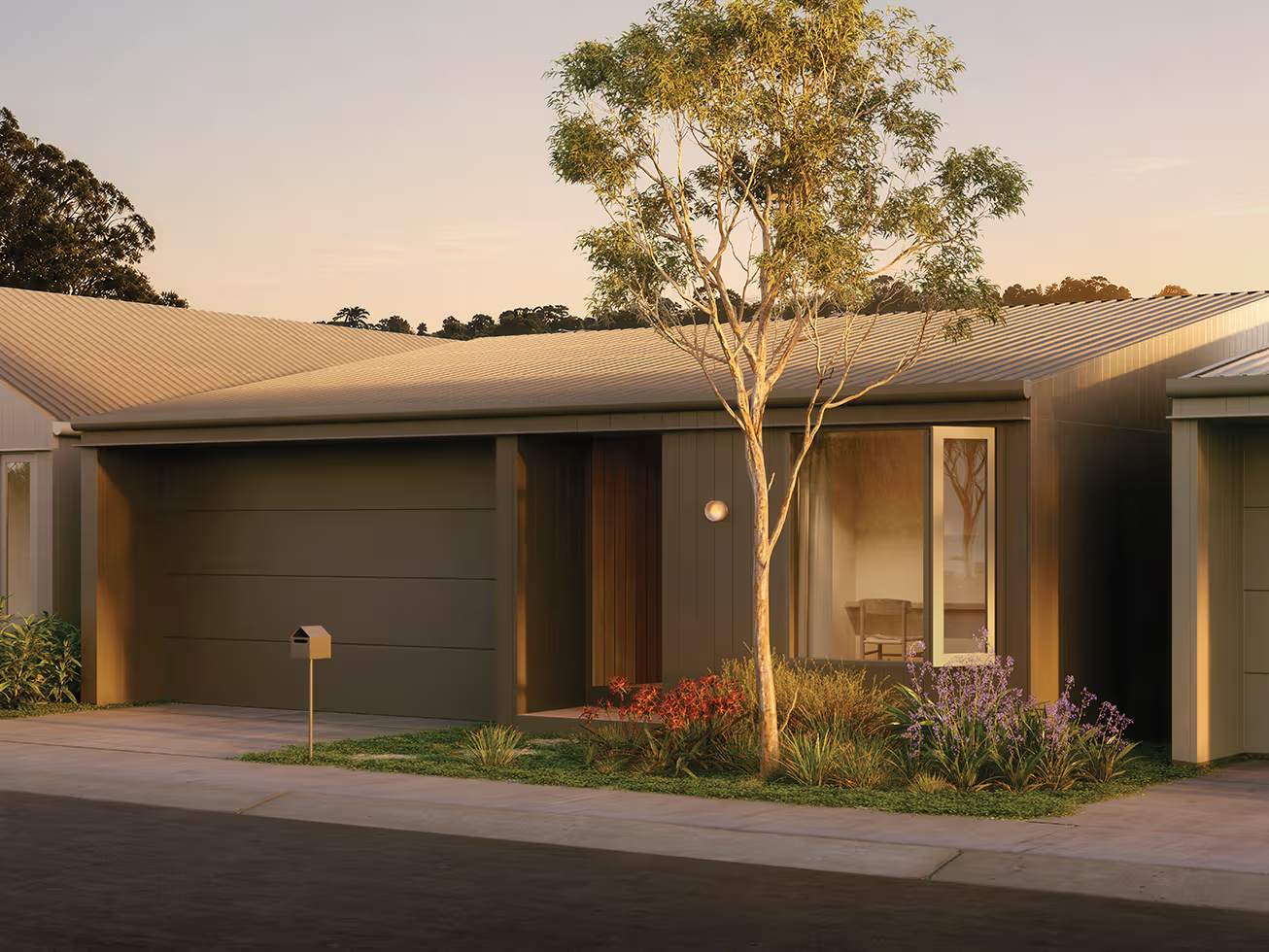 Modern single-story house with gray garage door, a tree, and landscaped front yard with flowers.