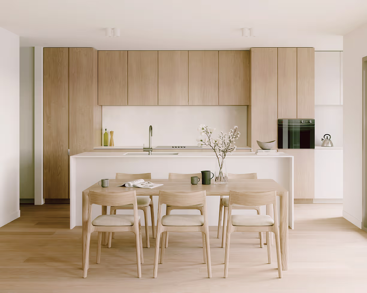 Minimalist kitchen with light wood cabinets, white island, dining table, chairs, and flower vase.