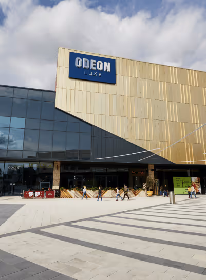 Modern cinema building with a large gold and black facade featuring the blue Odeon Luxe sign above the entrance.