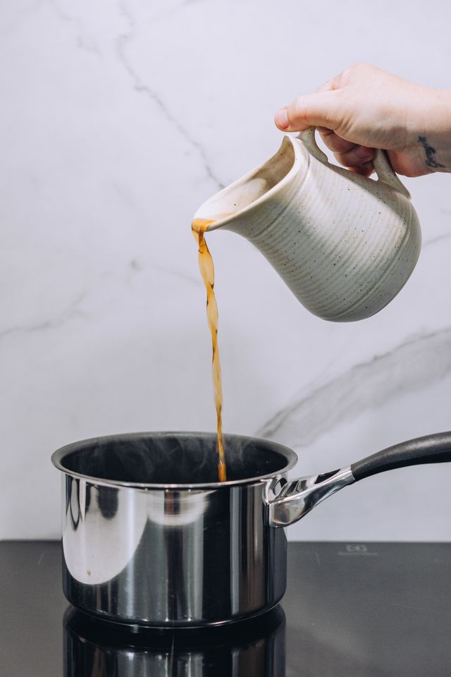 Prawn stock pouring from jug into saucepan
