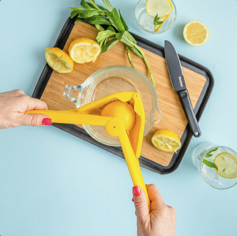 Fluicer in acrion - squeezing juice on tray with cut lemons