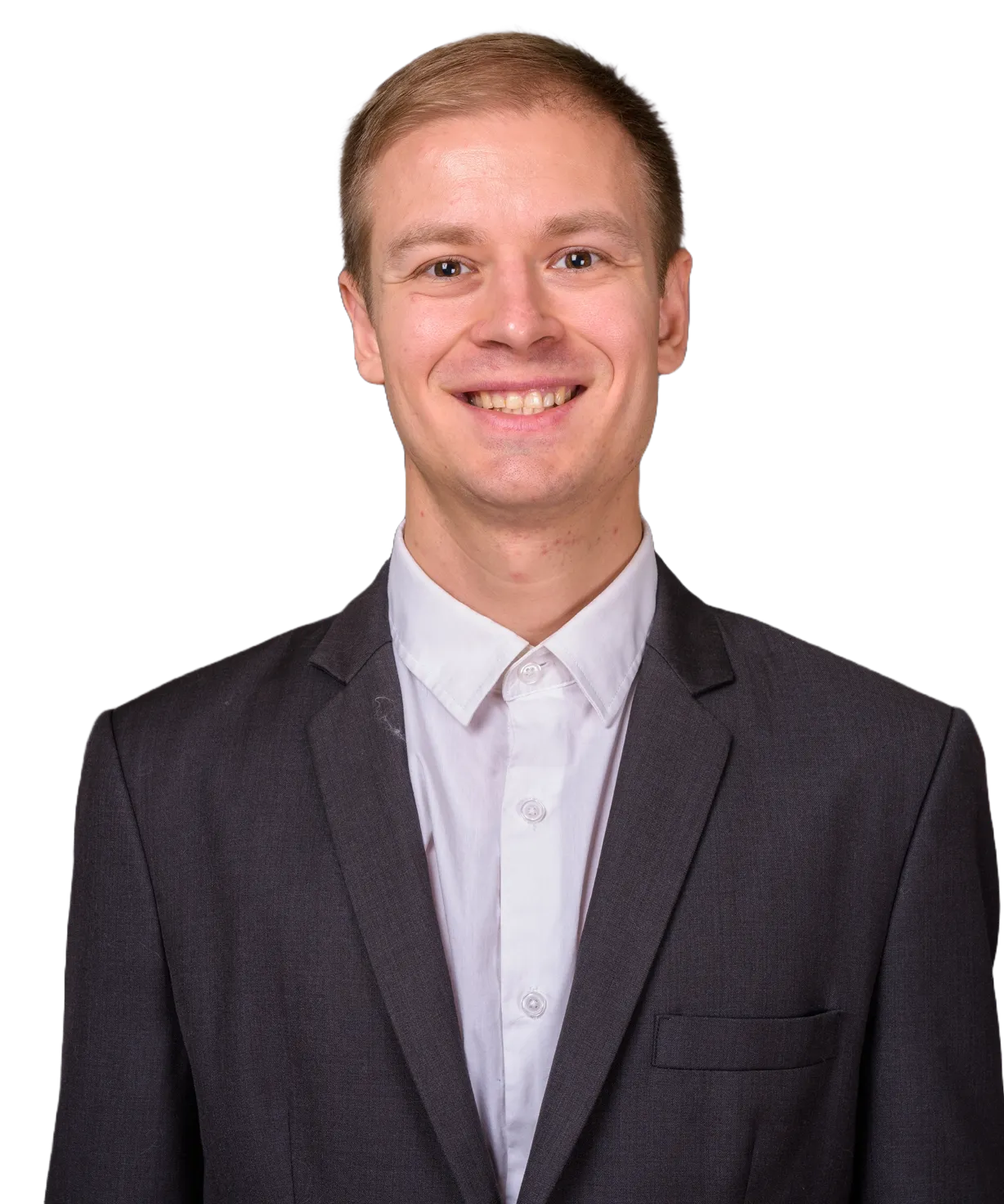 Smiling young man wearing a dark suit jacket and white shirt against a transparent background.