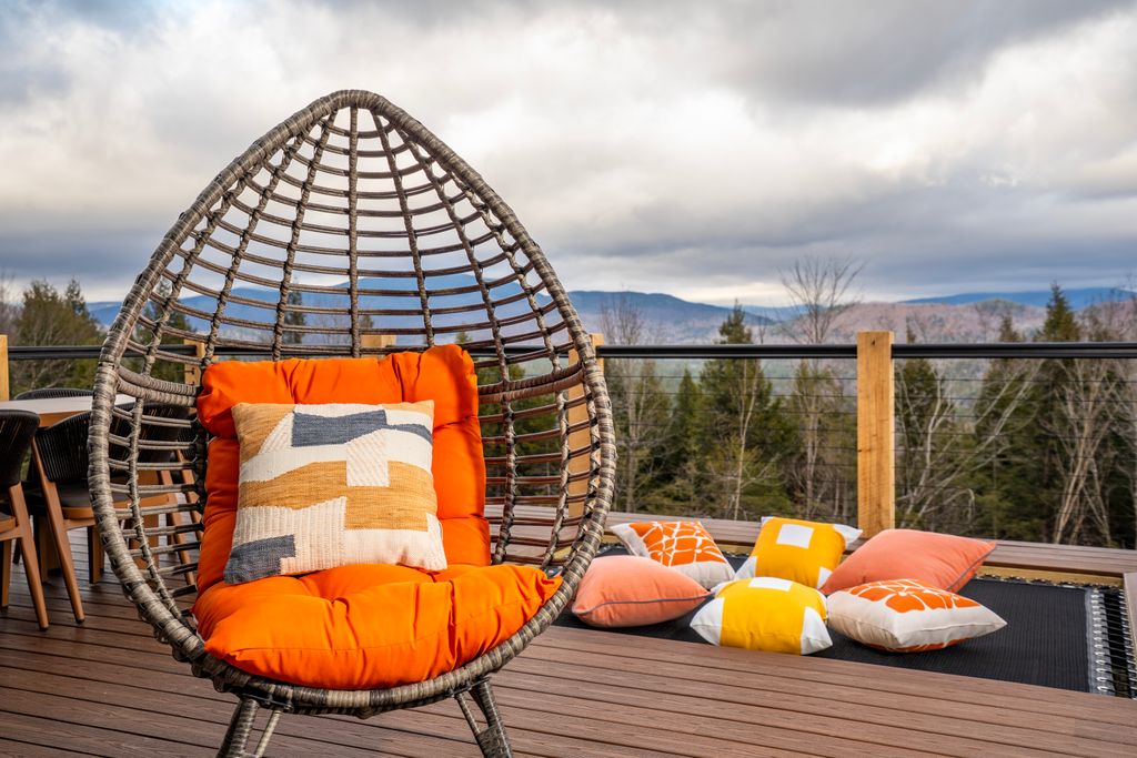 Cozy hanging chair on a mountain-view deck in Bethel, Maine designed for relaxing outdoors