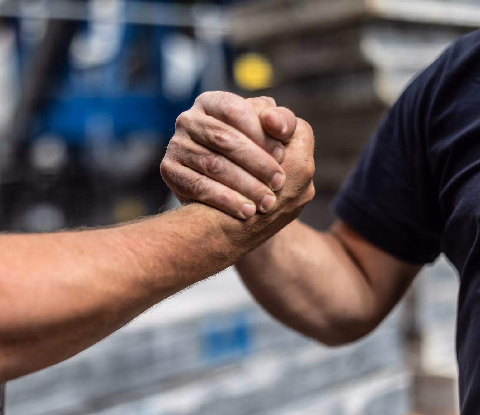 Zwei Personen schütteln sich mit festen Händen in einem Händedruck.