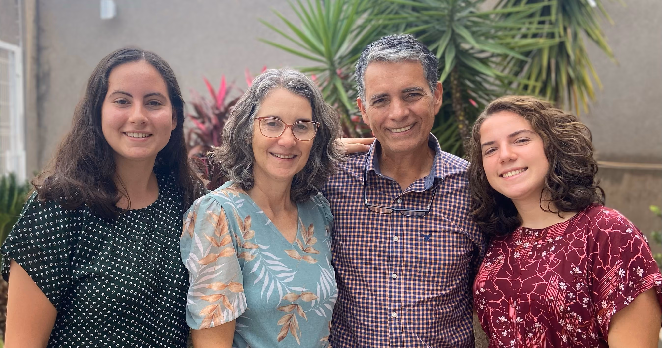 Família Bazan sorrindo de braços dados.