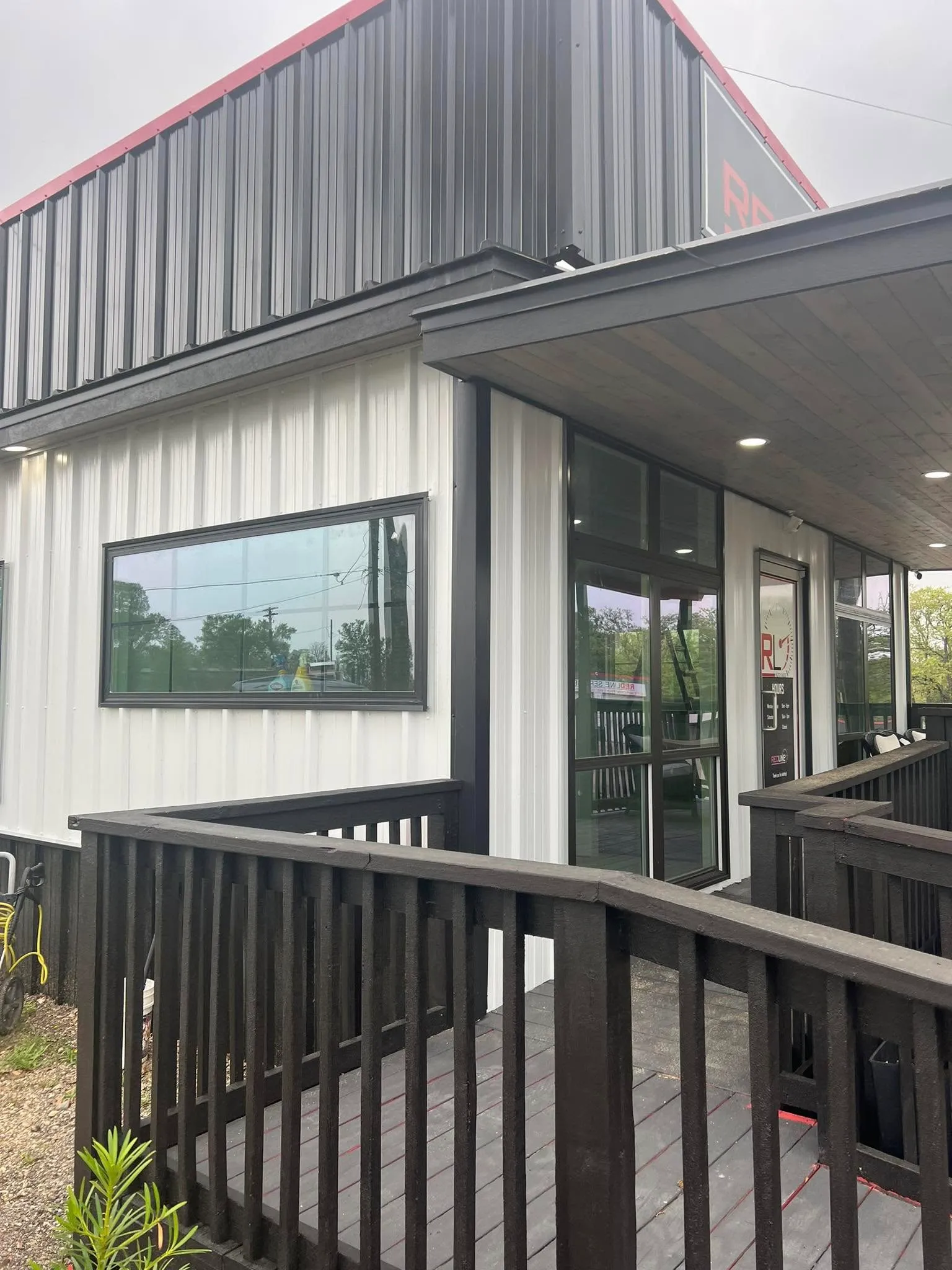 Modern building exterior with white and black metal siding with tinted windows.