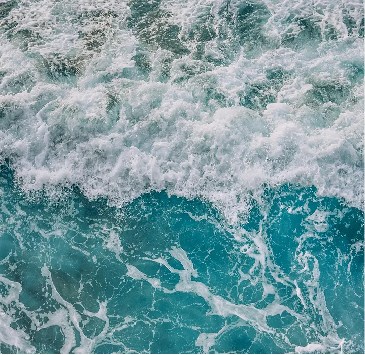 Foamy ocean waves with turquoise and deep blue water.