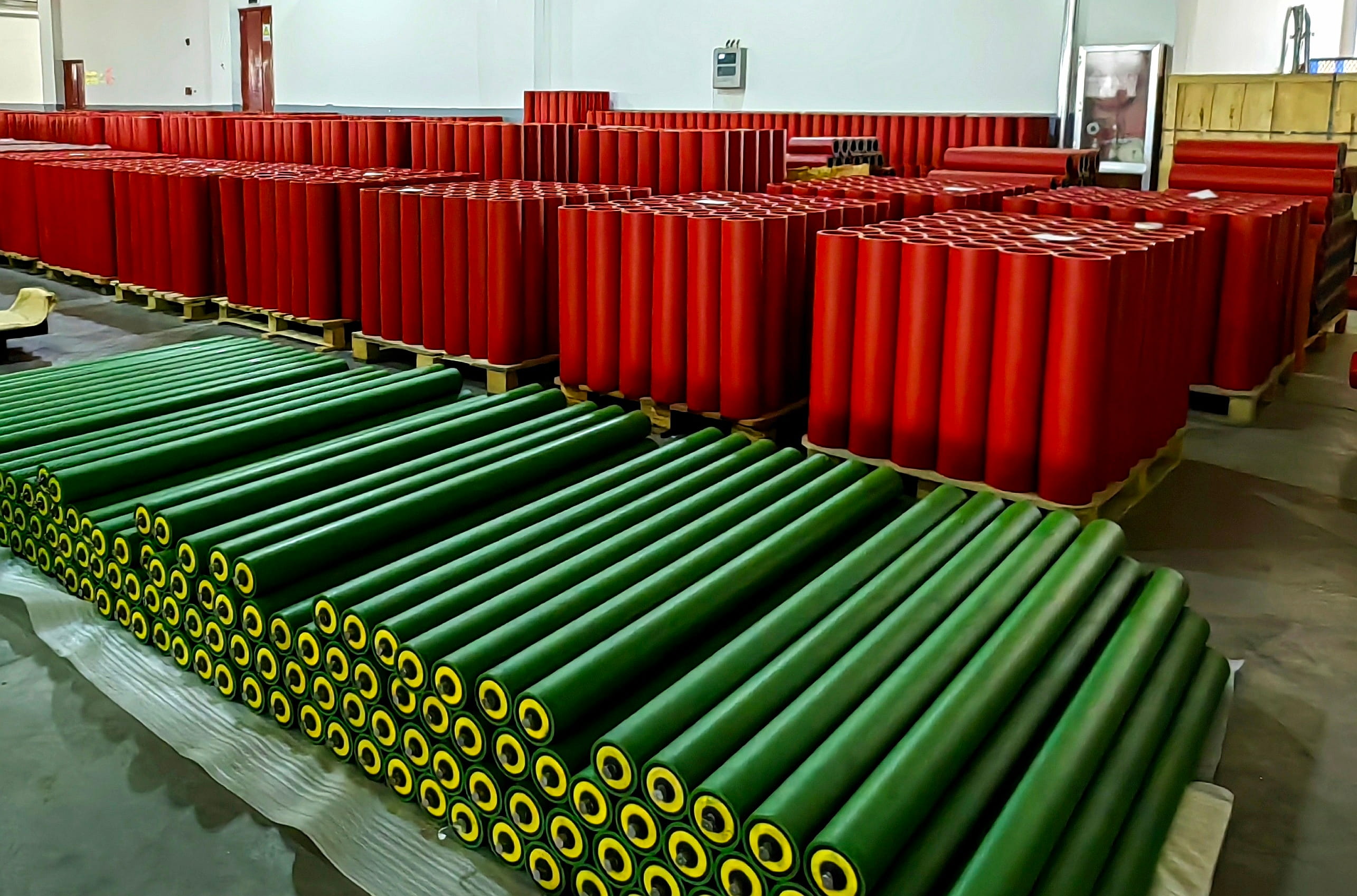 Convex red and green rollers in production facility