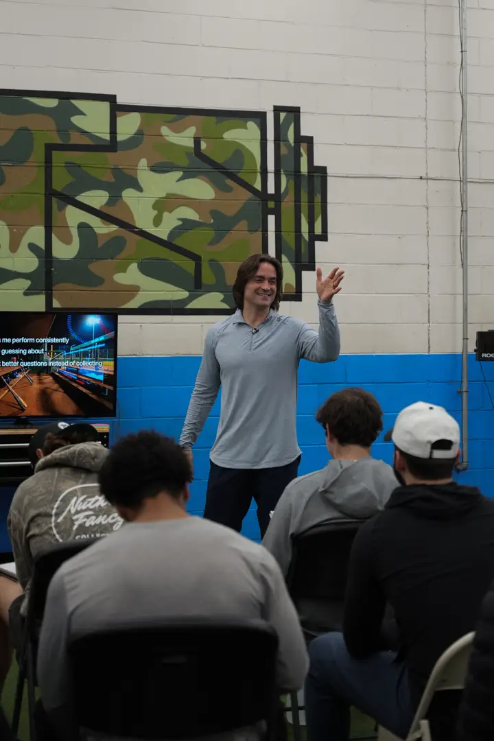 Coach Vinny Malts leading a group mindset session with young hockey players
