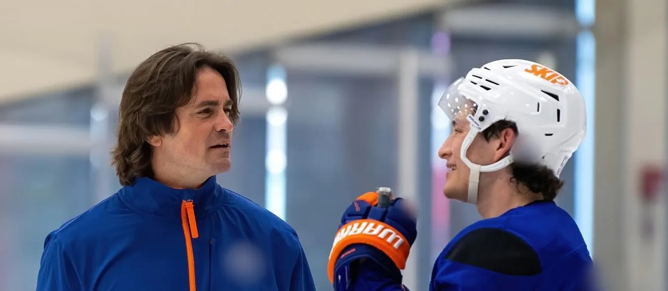 Coach Vinny Malts talking with a player on the ice