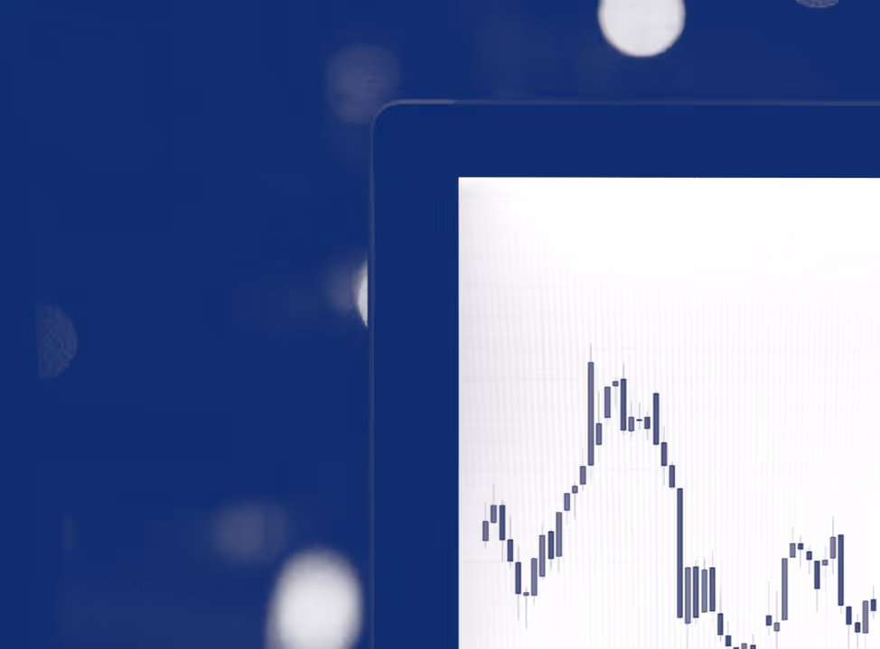 Grafico finanziario con candele giapponesi su uno schermo parzialmente visibile.