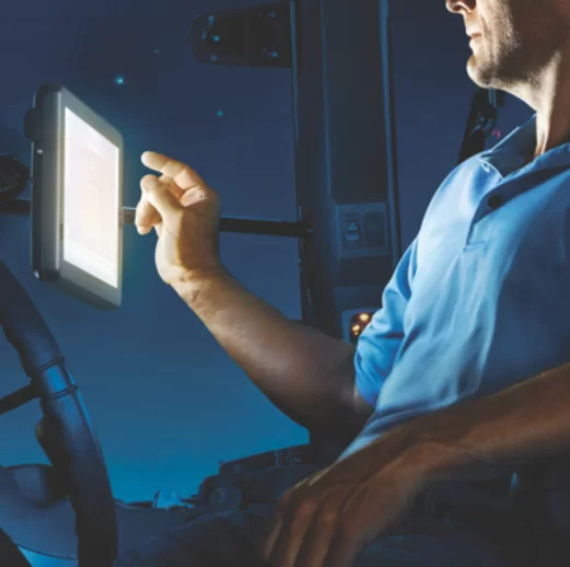 A person sitting on a chair and clicking on a tablet.