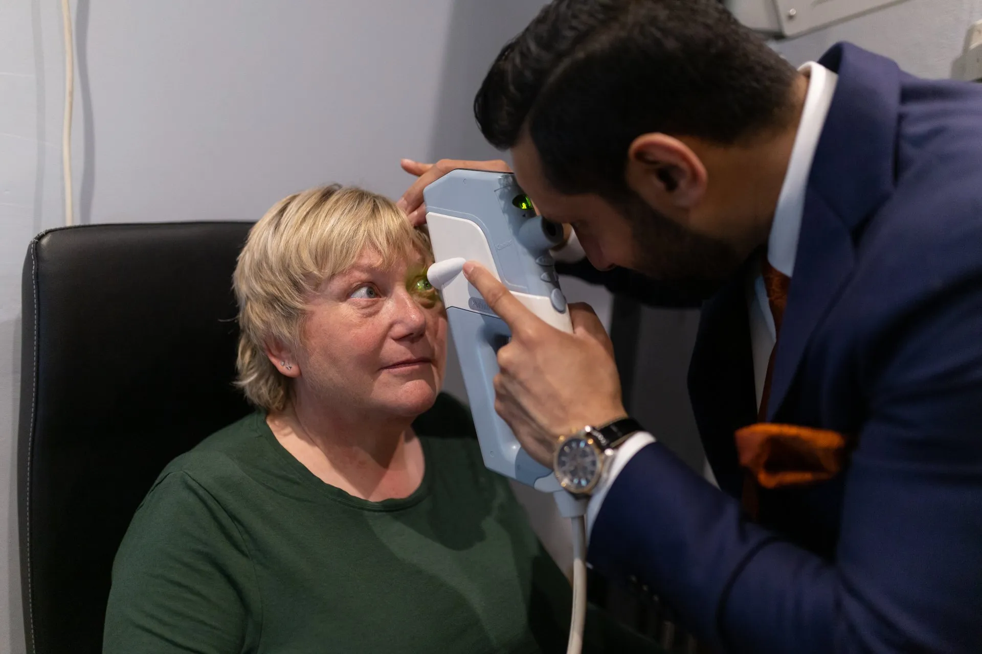 Doctor using thermal imaging camera to examine patient's forehead temperature
