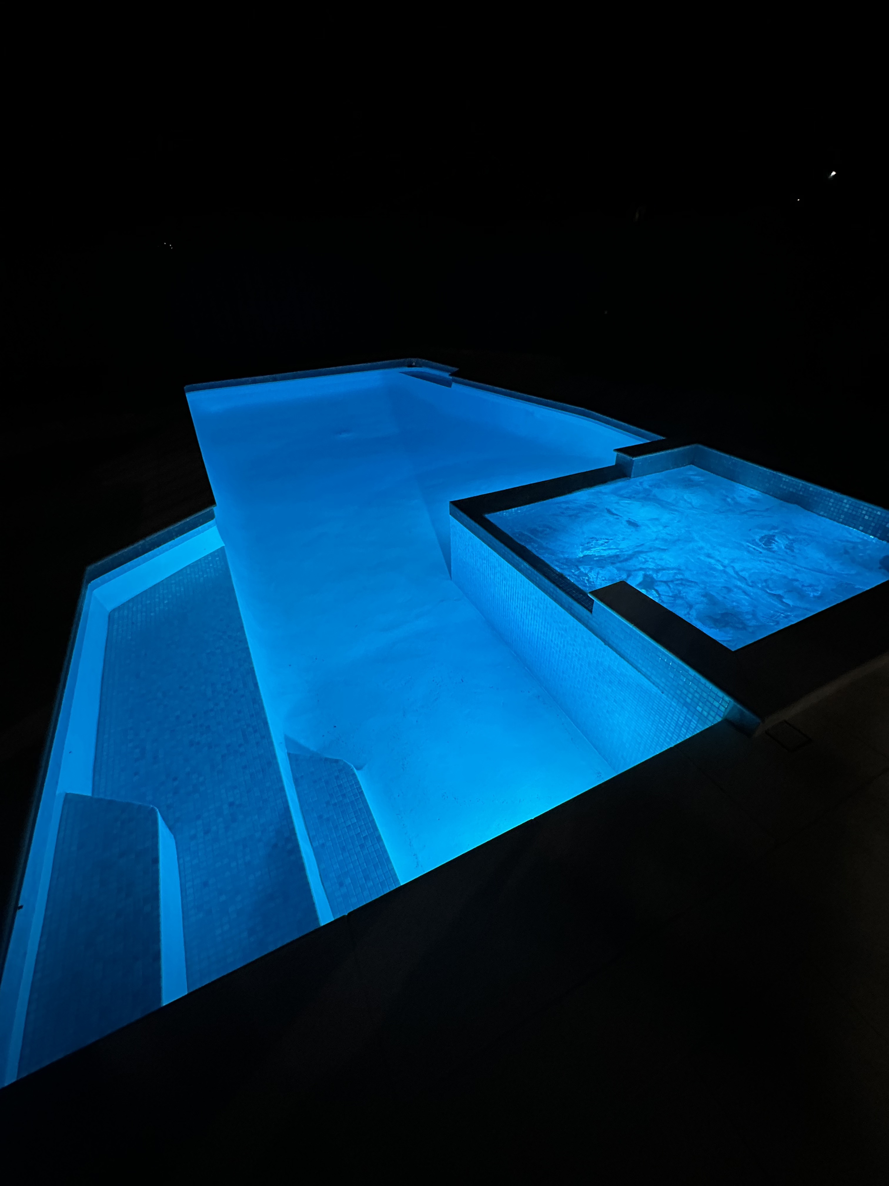 Four sets of black ceiling fan components with blades and wiring placed on molded fiber trays on a concrete floor.