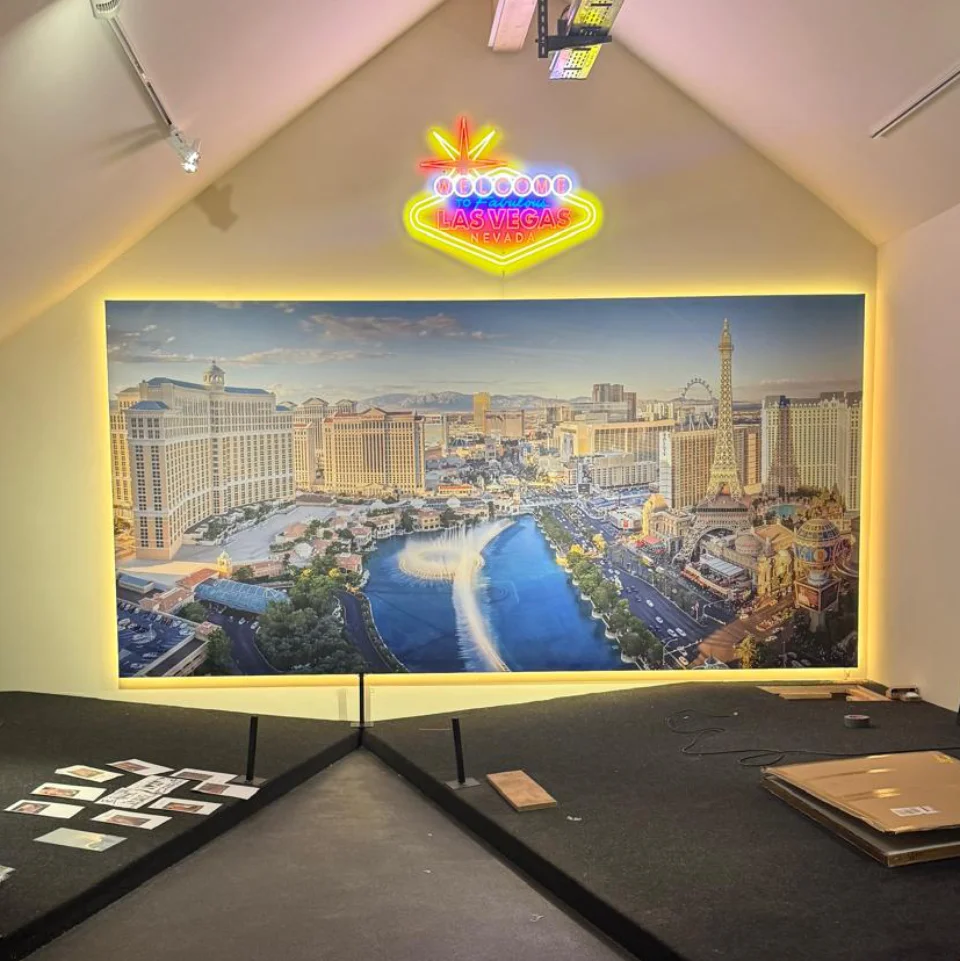 Leuchtendes Las Vegas Willkommensschild über einem großen beleuchteten Bild der Las Vegas Skyline mit dem Bellagio und dem Eiffelturm.