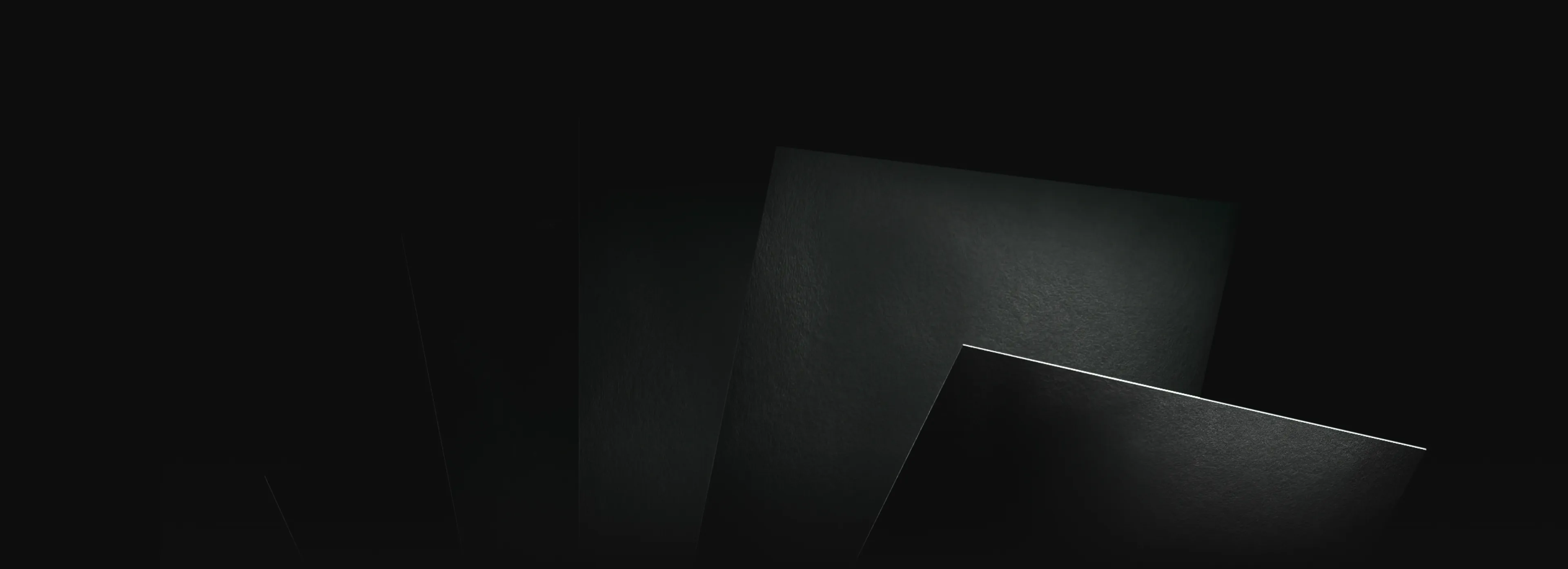 Close-up of overlapping dark textured sheets illuminated by a subtle light gradient.