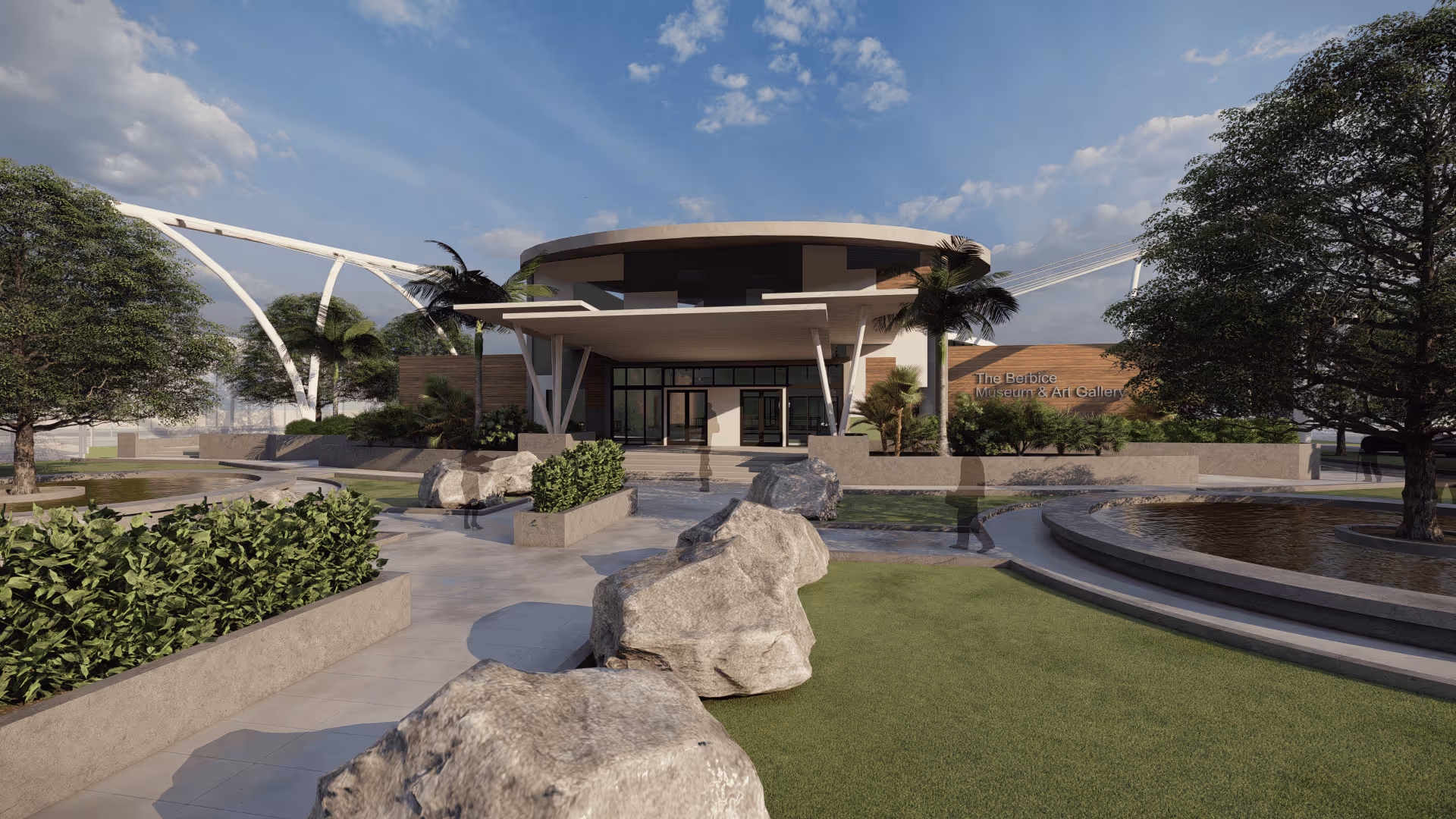 The Berbice Museum & Art Gallery building with landscaped grounds, large rocks, trees, and a circular water feature under a partly cloudy sky.