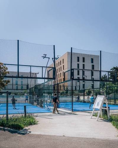 Terrains de padel de l’hôtel ibis Montpellier, construits par Sol Sportif, avec gazon bleu et joueurs