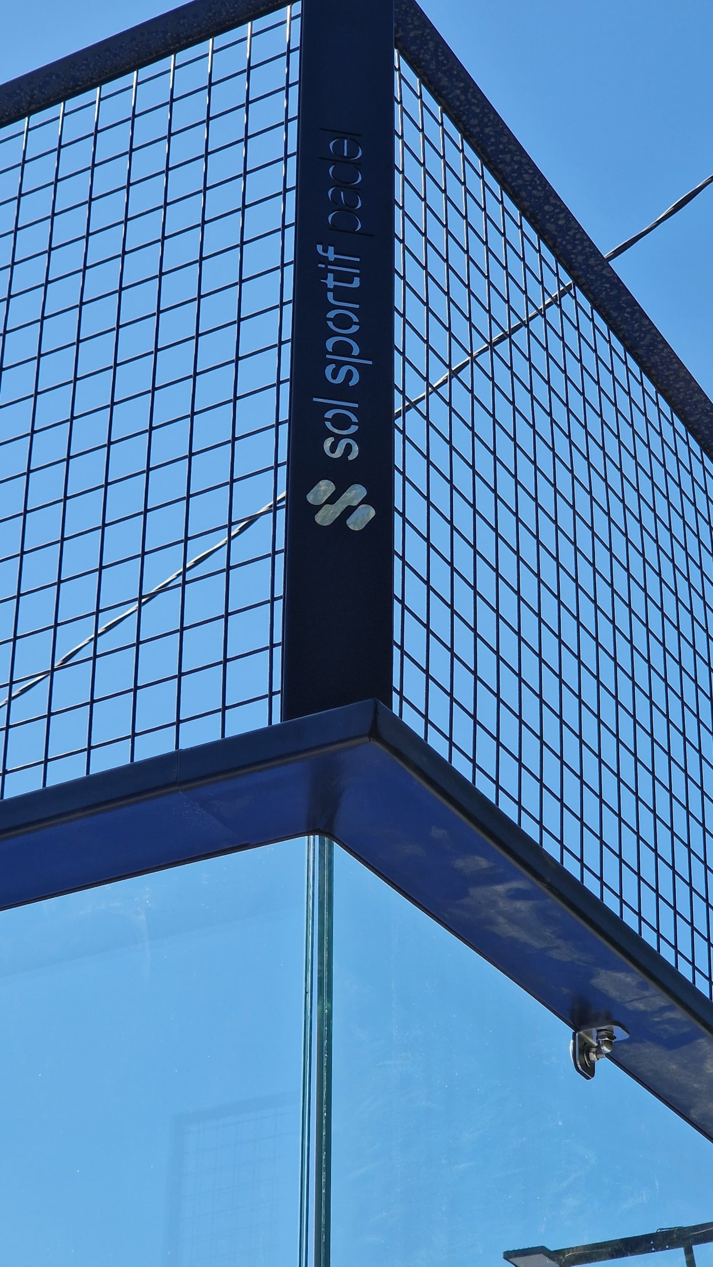 Angle d’un terrain de padel full panoramique à Collobrières, structure noire marquée Sol Sportif Padel