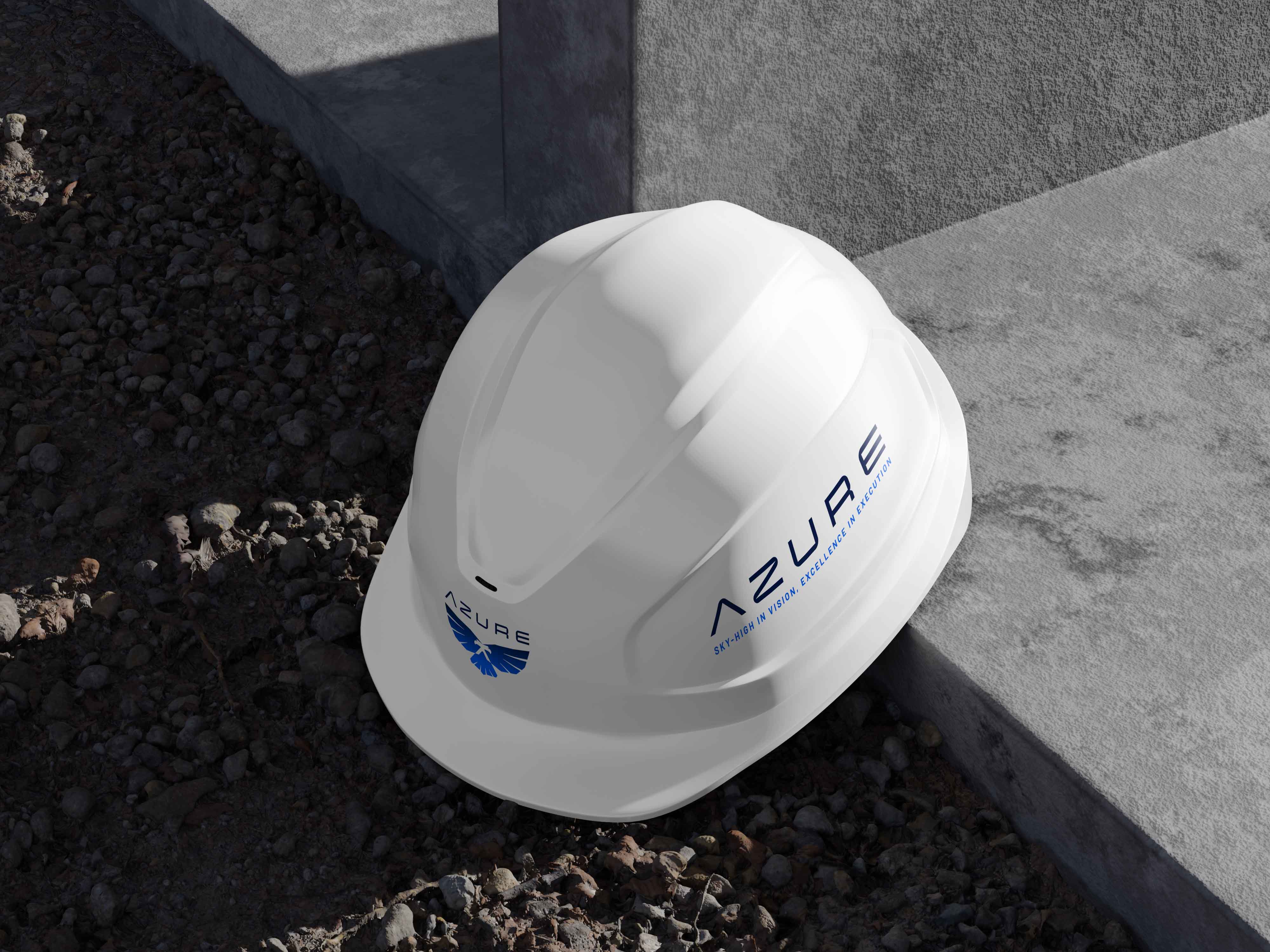White construction helmet with Azure logo and the text 'Sky-High in Vision, Excellence in Execution' resting on gravel near a concrete edge.