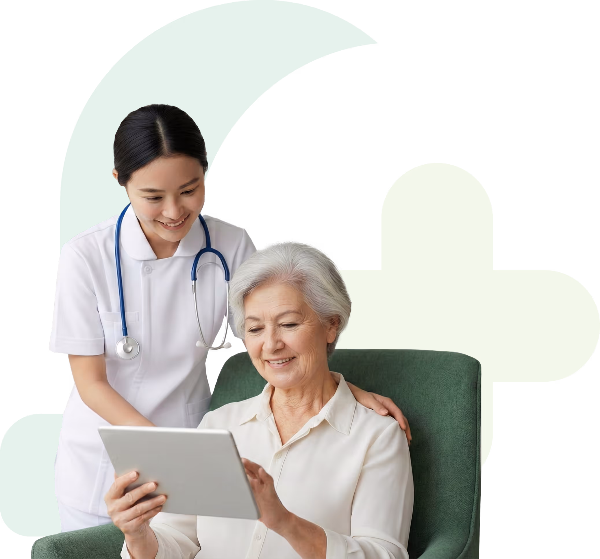 Smiling female healthcare worker with stethoscope assists elderly woman using a tablet while sitting in a green armchair.