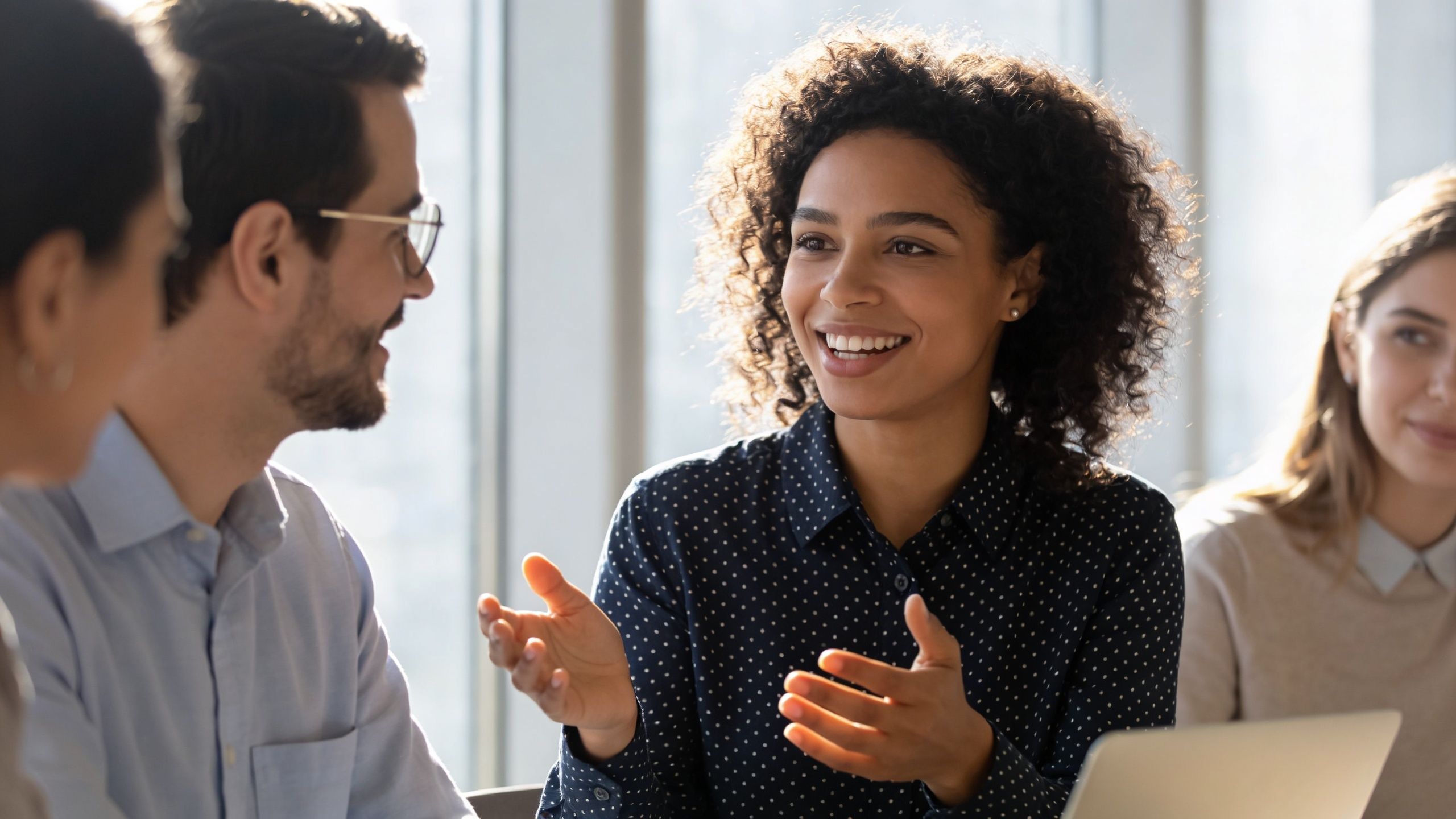 A diverse team of professionals discussing business ideas and collaborating during a friendly office meeting.