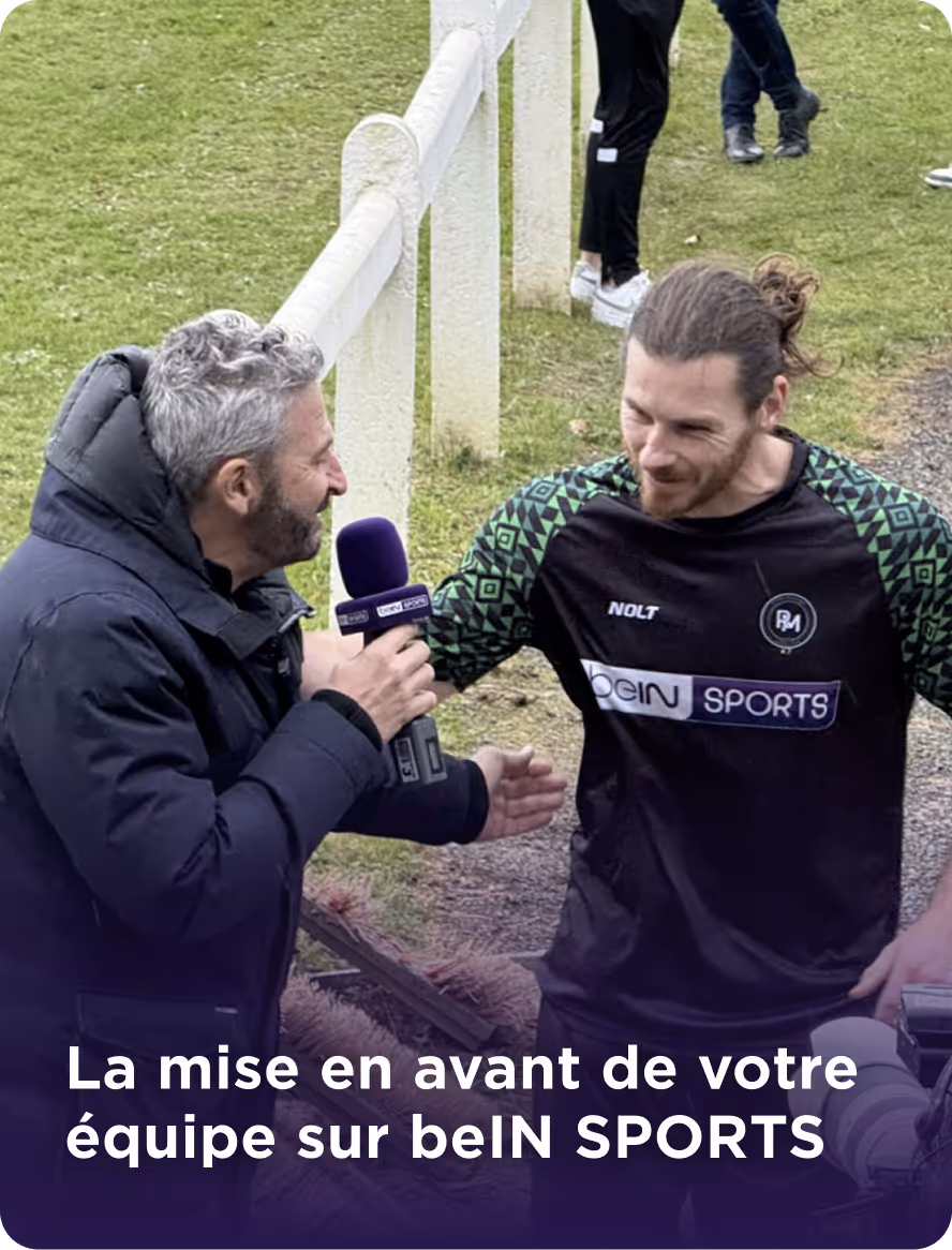 Un journaliste tenant un micro beIN SPORTS interviewe un homme en tenue de sport noire avec des motifs verts sur le terrain.