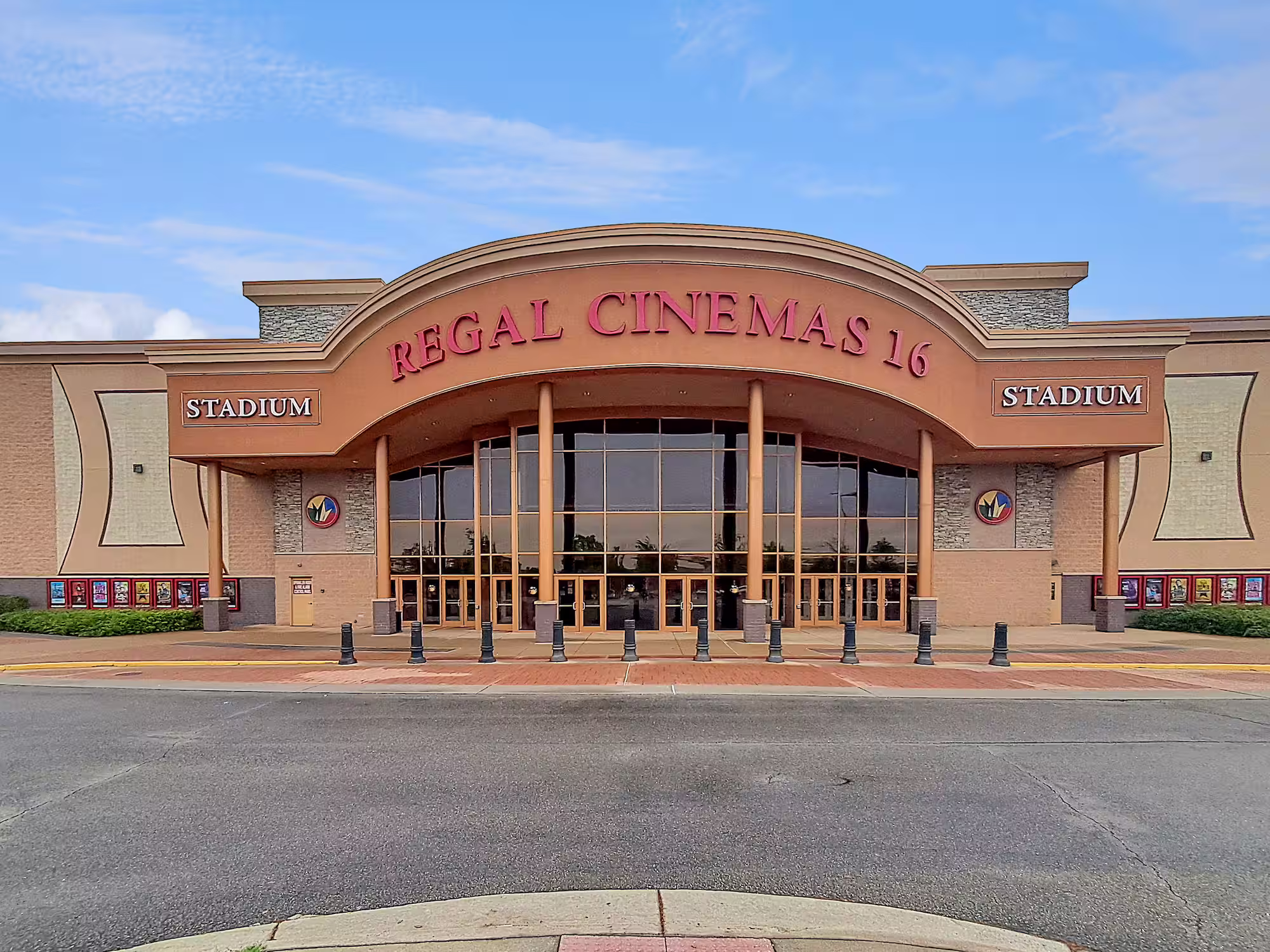Front entrance of Regal Cinemas 16 with large glass doors and stadium seating signs on either side.