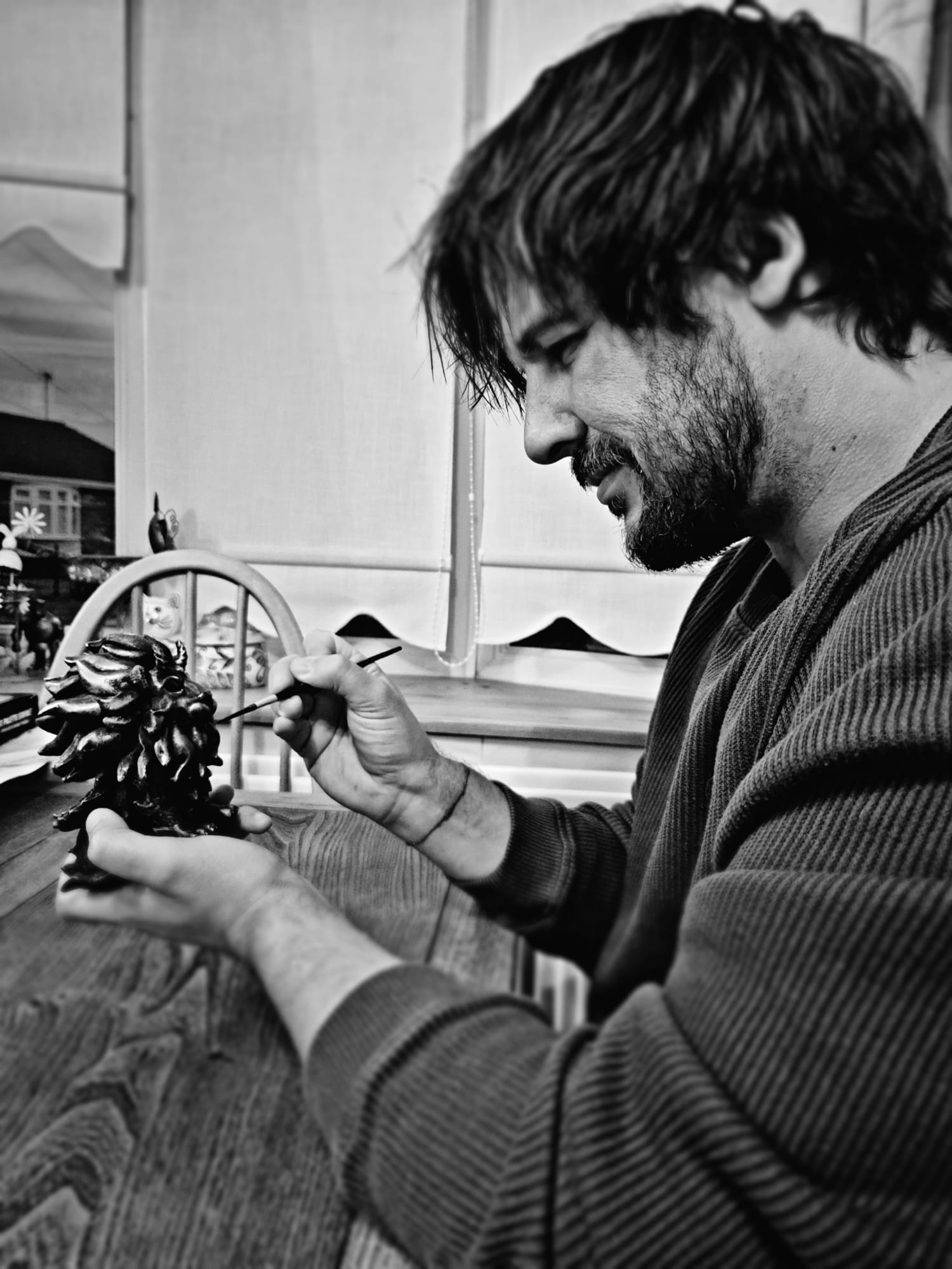 Artist James Lamb painting an Occulties figurine at his worktable.