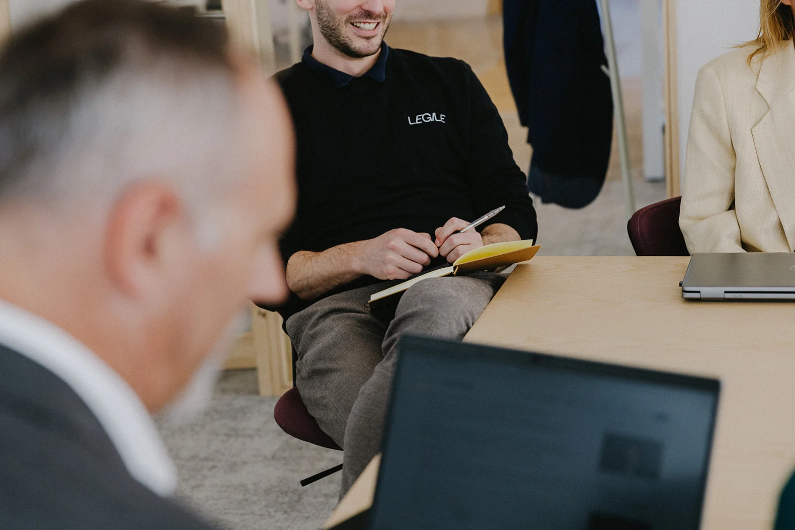 Legile team member in a client meeting, taking notes and providing hands-on legal support