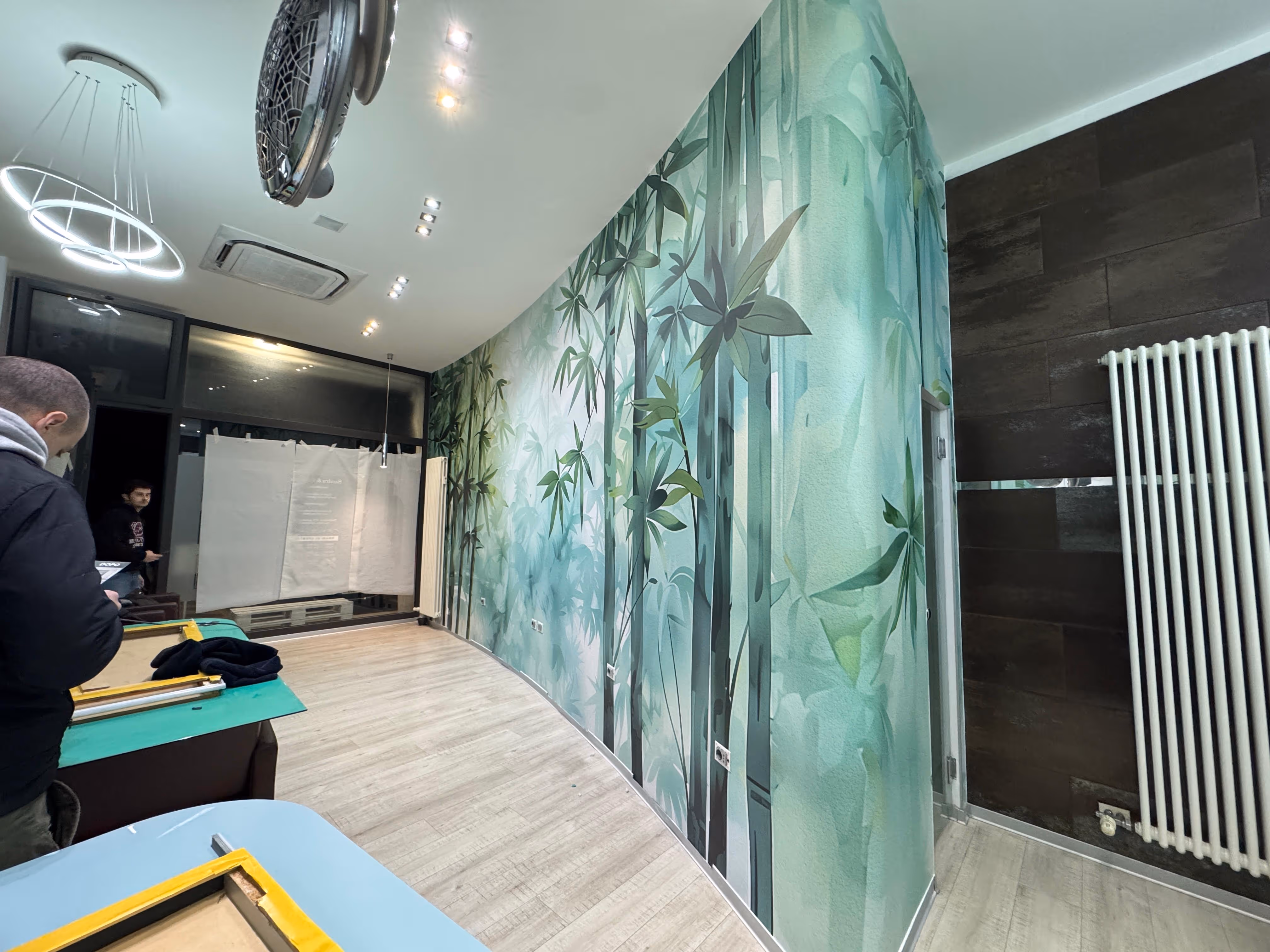 Allestimento fieristico o retail con decorazione pareti effetto bamboo verde e illuminazione a faretti.
