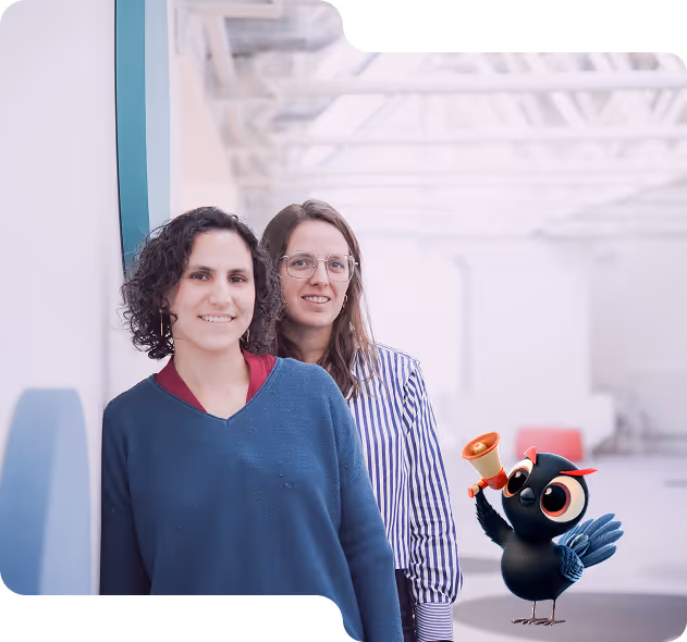 Deux femmes souriantes posant dans un espace lumineux, avec un oiseau animé noir tenant un mégaphone à leurs côtés.