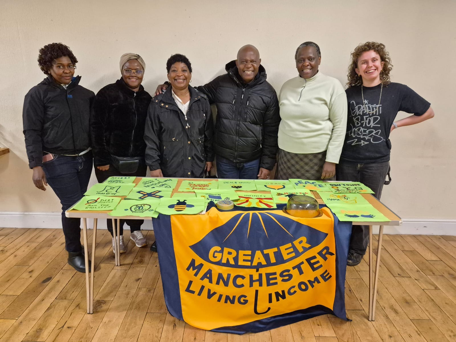 Community members smile while creating a banner