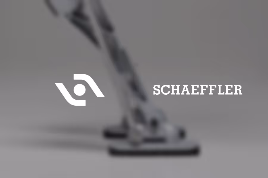 Close-up of a metallic robotic leg with articulated joints against a gray background.