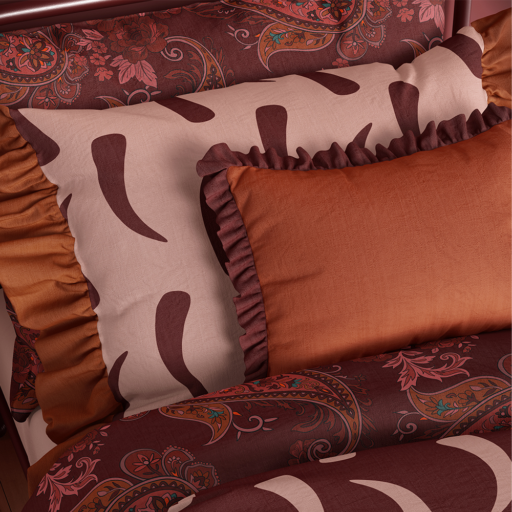 A mockup of Paisley Maroon, Abeng Spring and Abeng Dusk prints on bedding.
