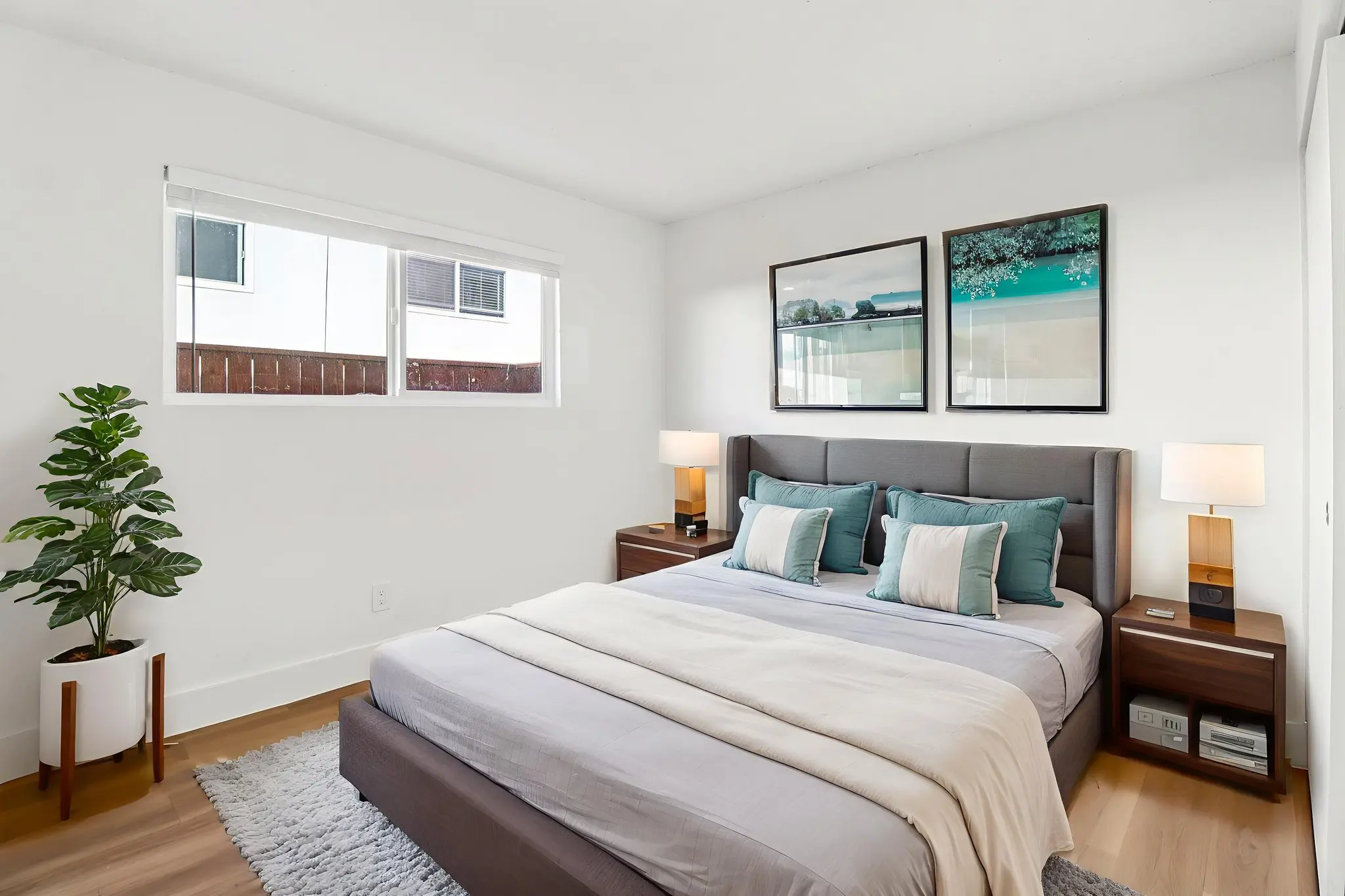 Bedroom with bed, plant, and bedside table