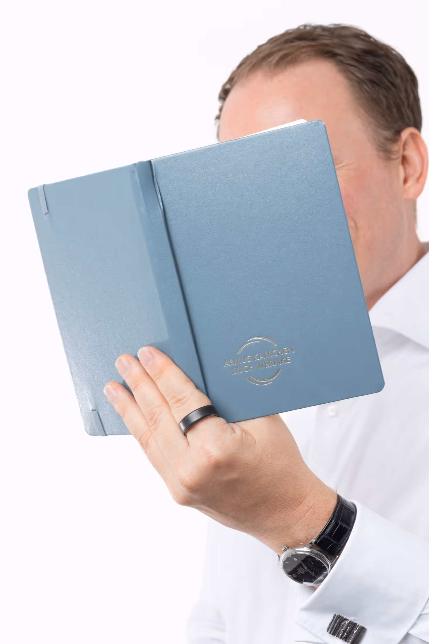 Christian Wermke hält ein Buch vor sein Gesicht