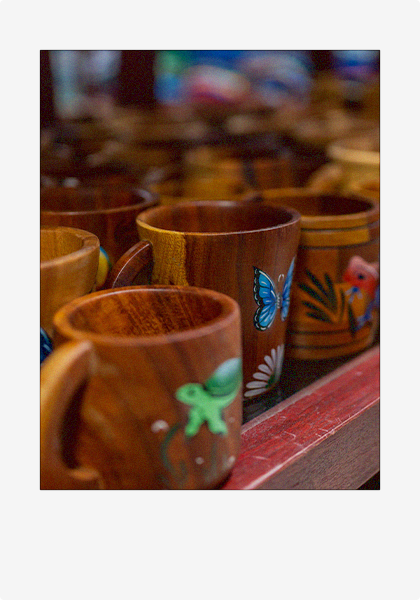 A polaroid picture of hand-carved and painted wooden mugs.