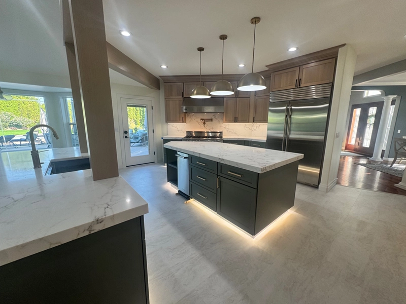 White countertops with bold gray veining on a kitchen island and perimeter run, with a matching slab backsplash.