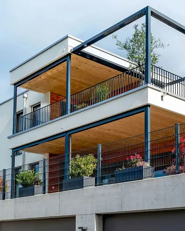 Modernes Holzhaus mit Doppelgarage und holzverkleideten Balkonen – nachhaltige Architektur und moderner Holzbau geplant von Vögeli Architekten