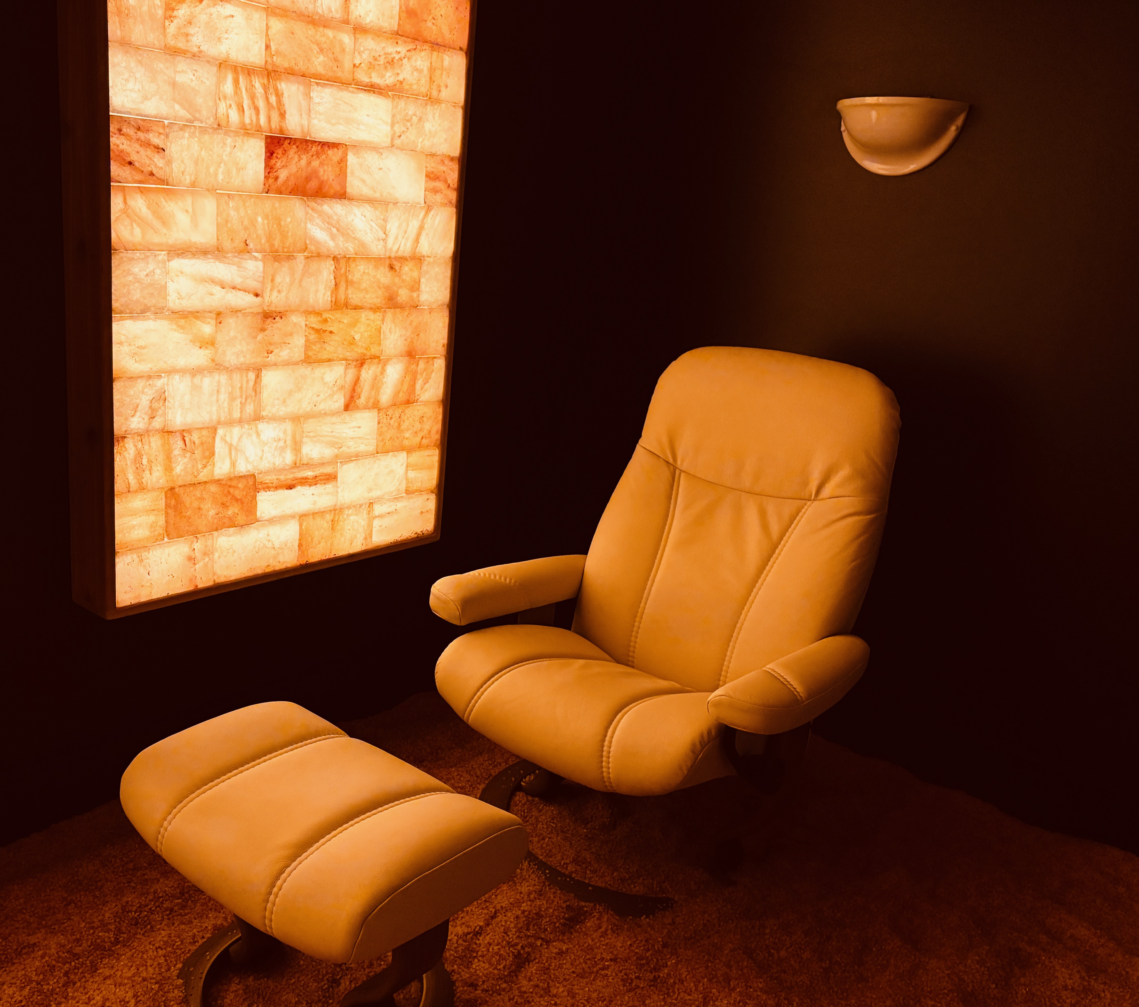 A dimly lit room featuring a large illuminated salt wall panel.